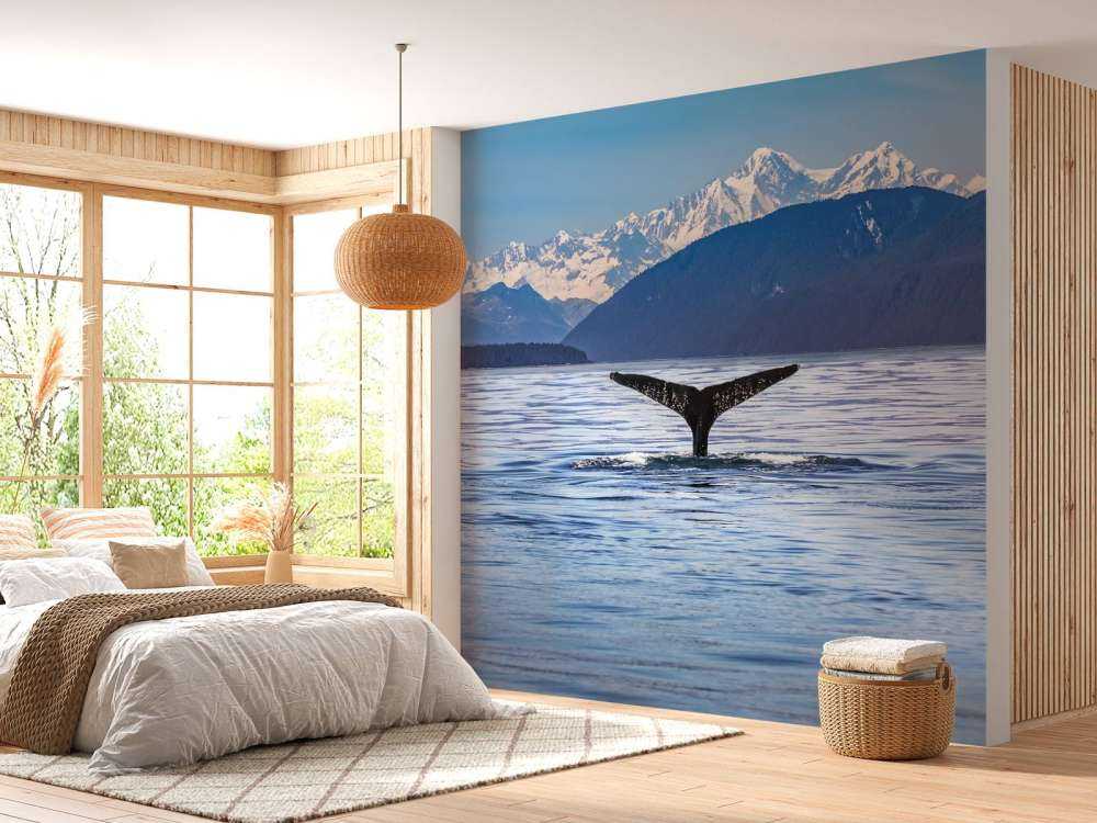 Baleine plongeante avec des montagnes à l'arrière-plan