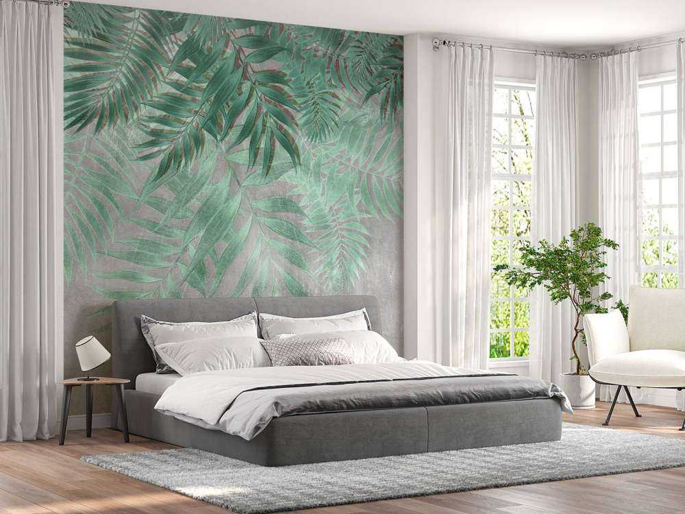 Feuilles de palmier vertes sur un mur en béton gris