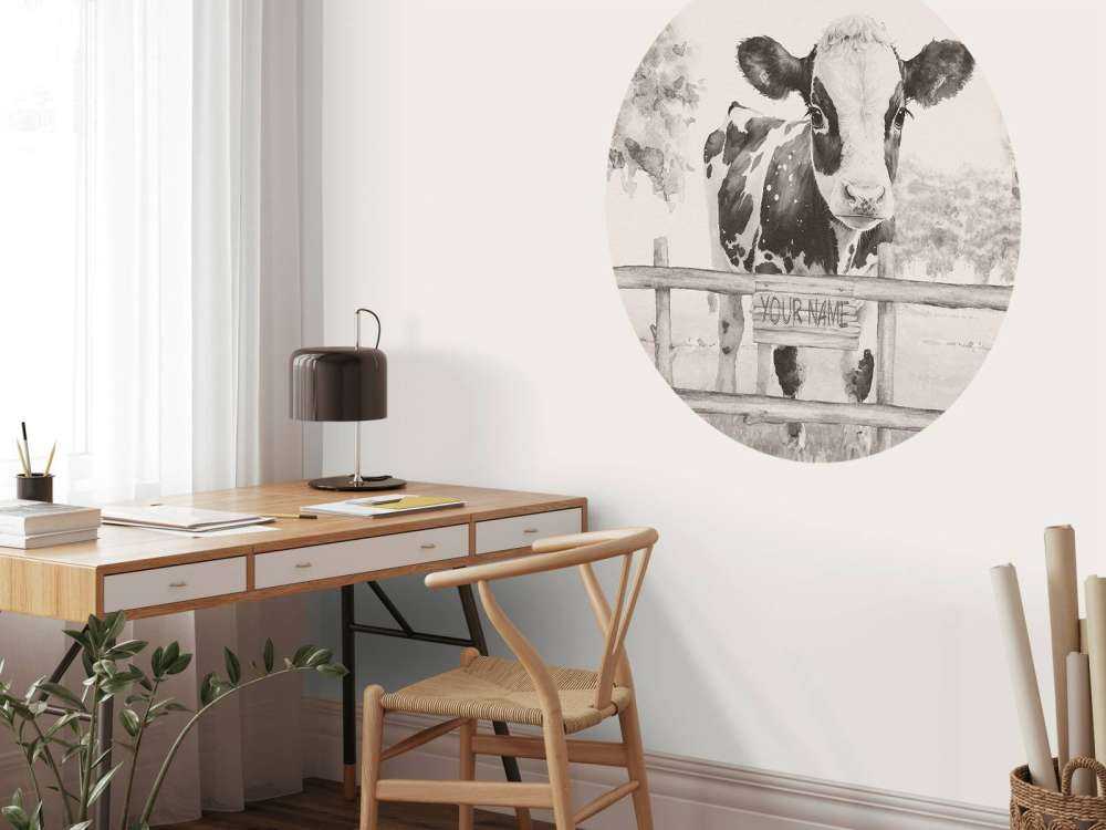 Bébé vache dans un pré beige