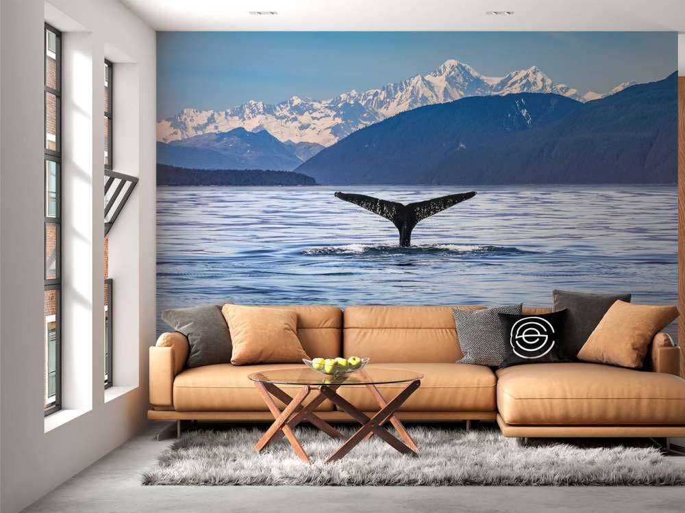 Baleine plongeante avec des montagnes à l'arrière-plan