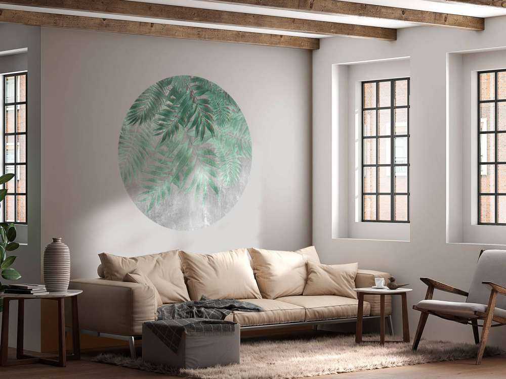 Feuilles de palmier vertes sur un mur en béton gris