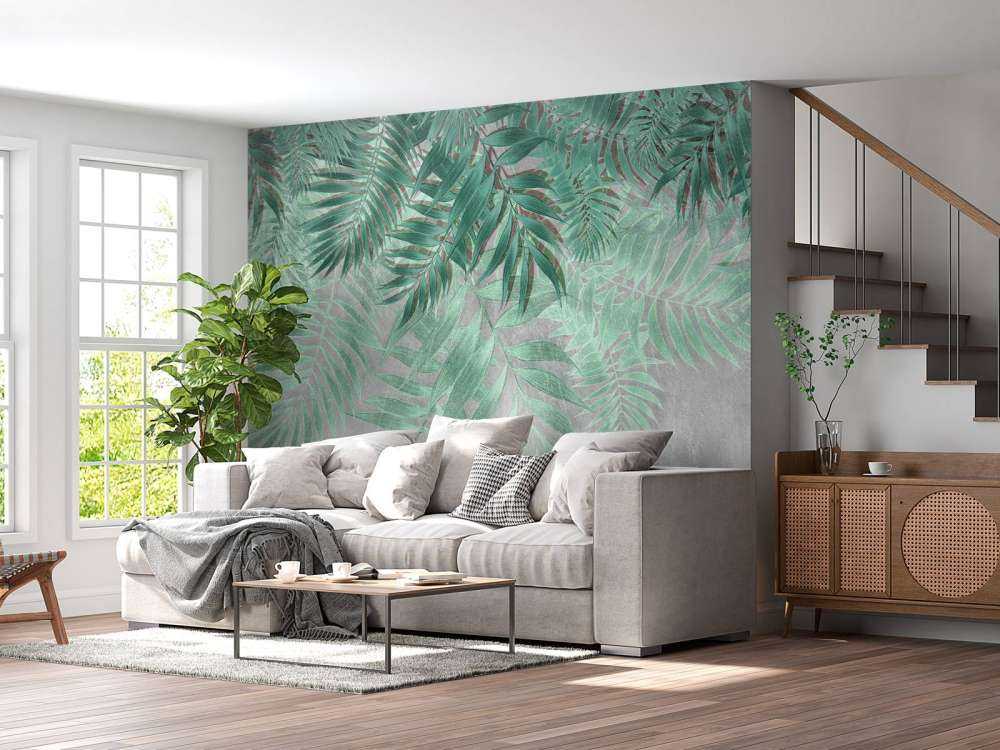 Feuilles de palmier vertes sur un mur en béton gris