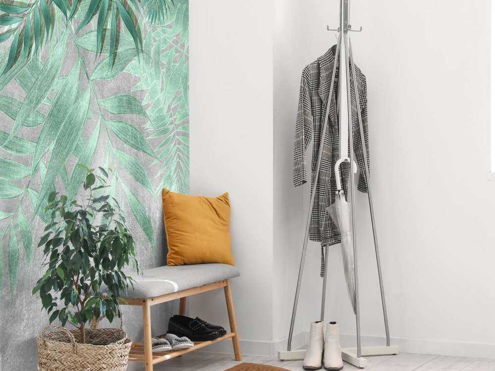 Feuilles de palmier vertes sur un mur en béton gris
