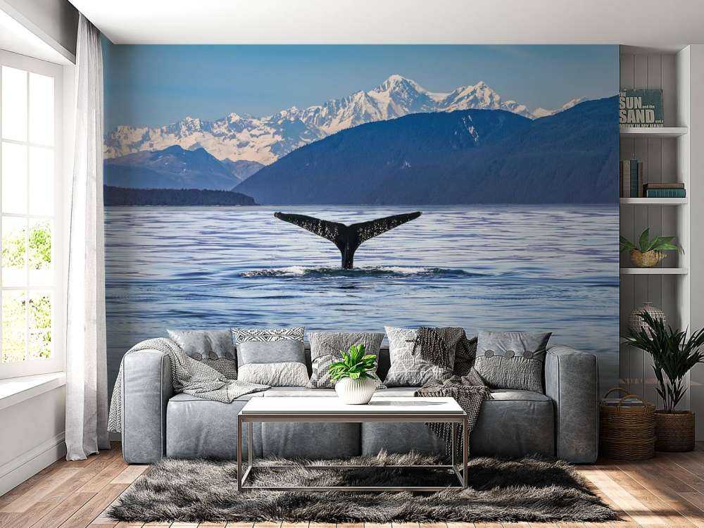 Baleine plongeante avec des montagnes à l'arrière-plan